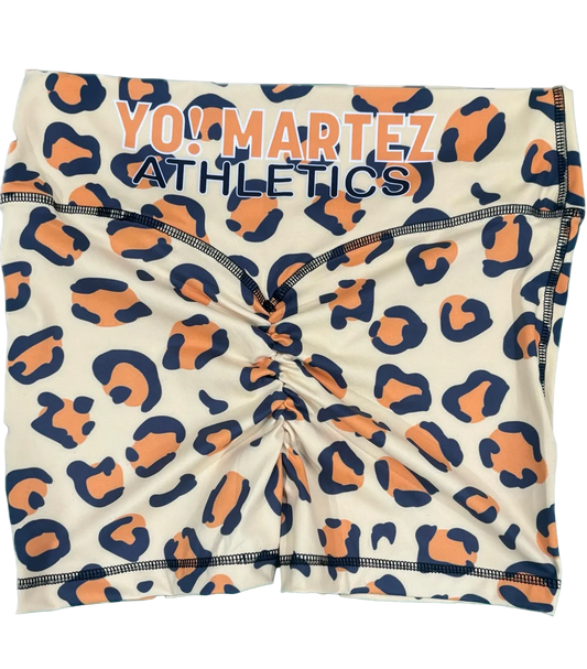 Athletic shorts featuring a navy blue and orange leopard print pattern on a cream background, with 'YO! MARTEZ ATHLETICS' printed across the waistband.
