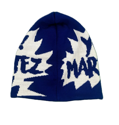 A navy blue knit beanie hat featuring large white graphic patterns and stylized text on the front and sides, shown against a plain white background.