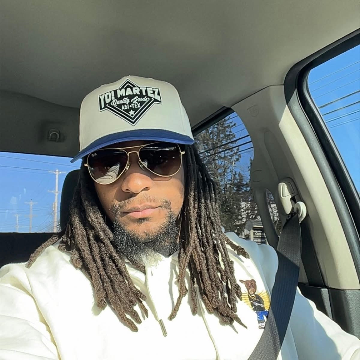 Model styling blue embroidered
"Yo! Martez — Quality Goods" hat