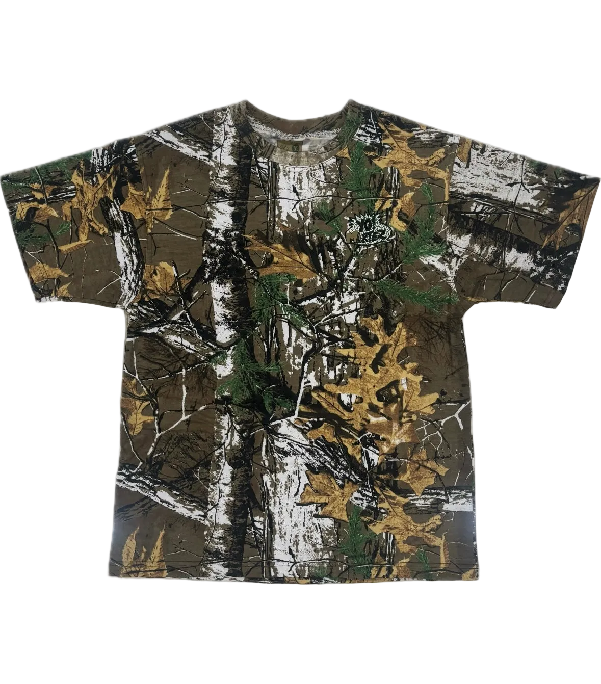 A short-sleeve crewneck t-shirt featuring a realistic woodland camouflage pattern with brown tree trunks, green pine needles, and golden-yellow autumn leaves on a white background.