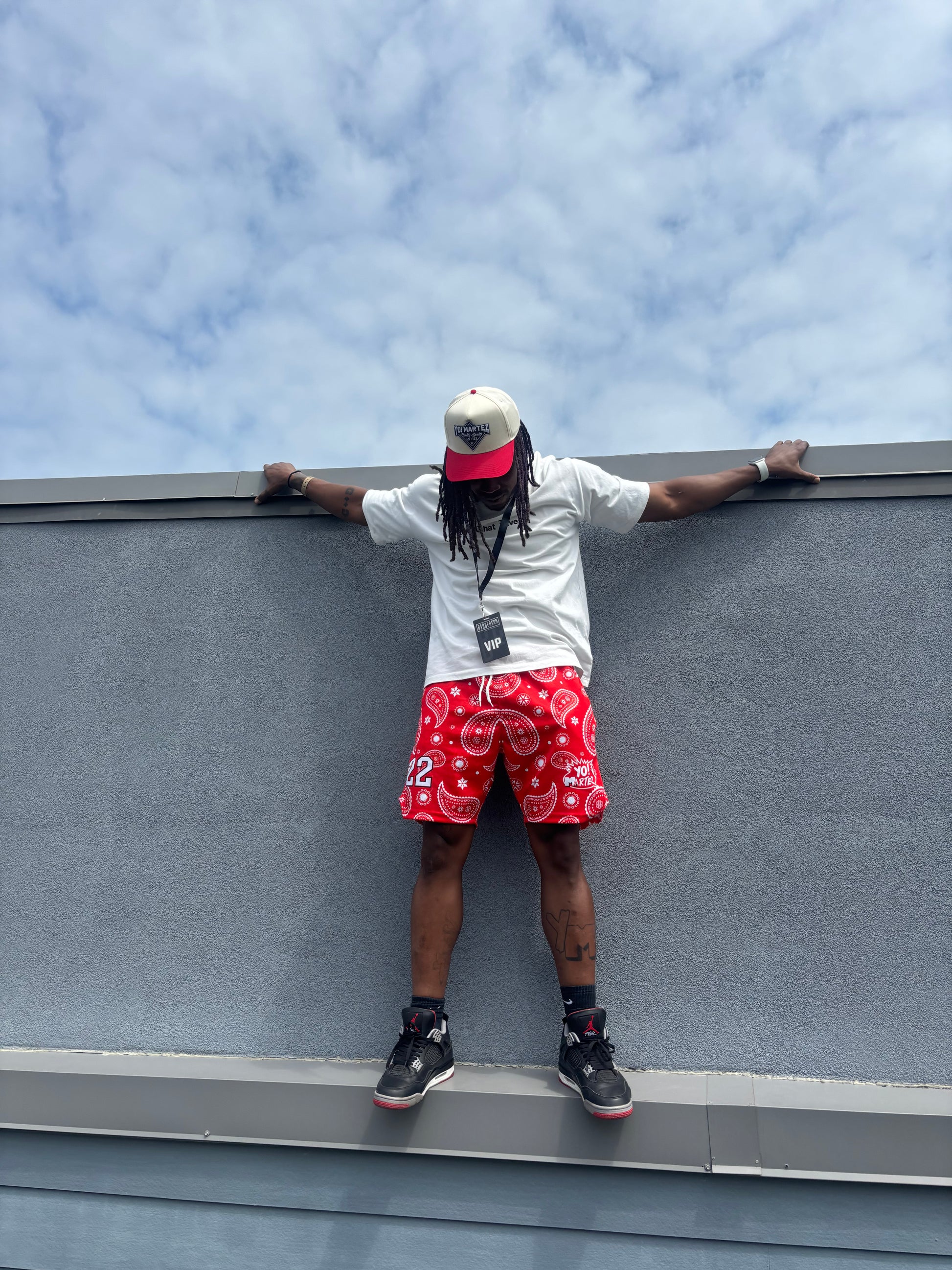 Model styling red embroidered
"Yo! Martez — Quality Goods" hat