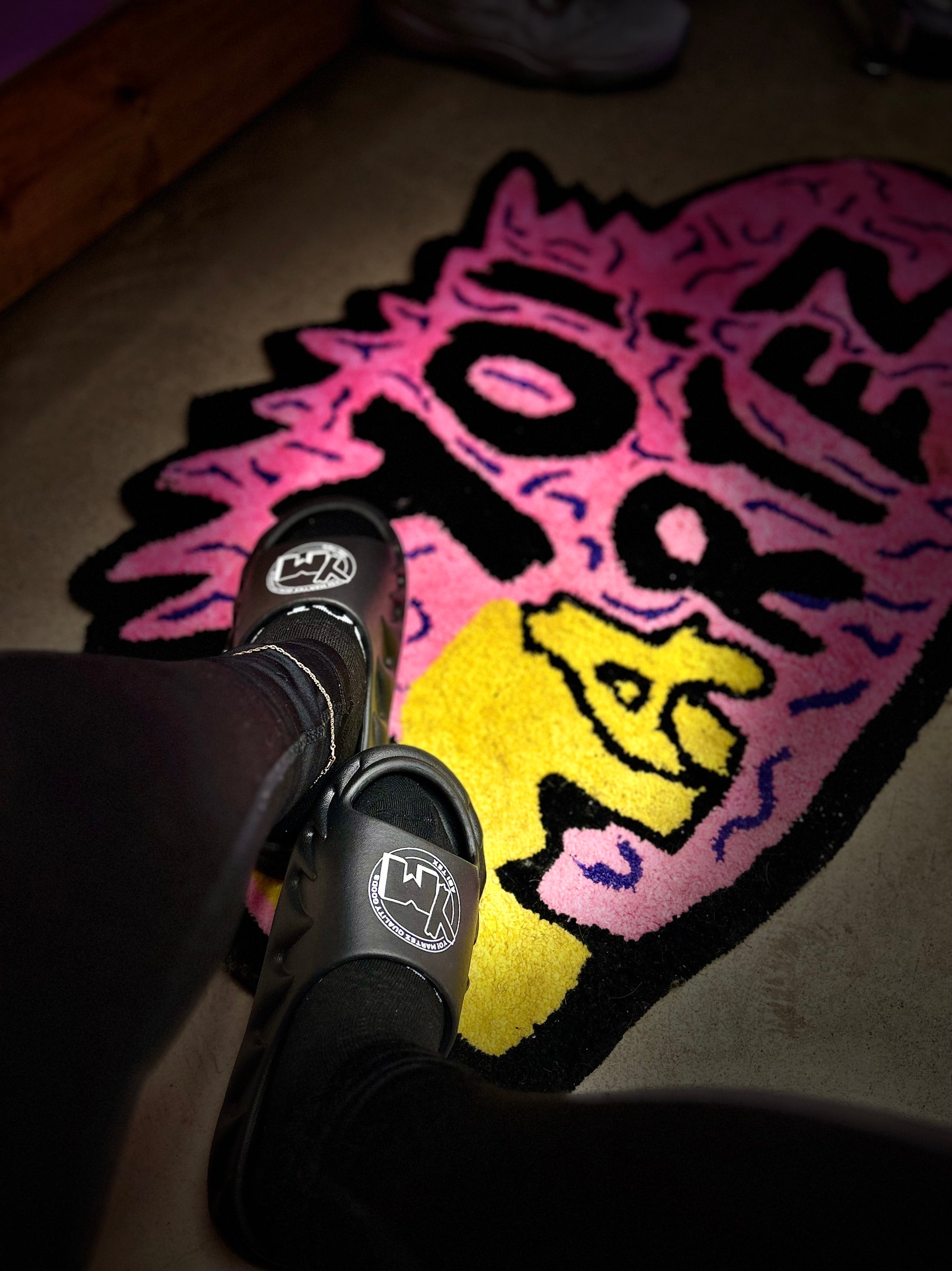 A pair of black slides with a white YM logo on the footbed