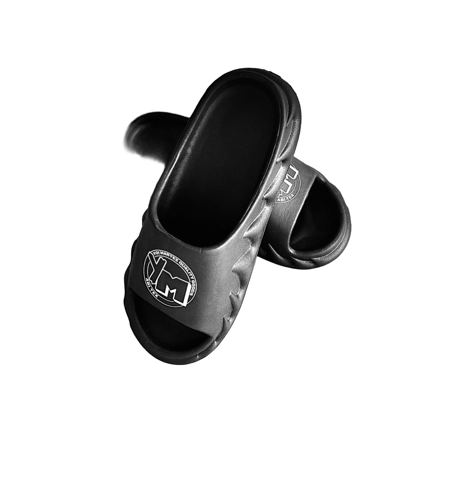 A pair of black slides with a white YM logo on the footbed,