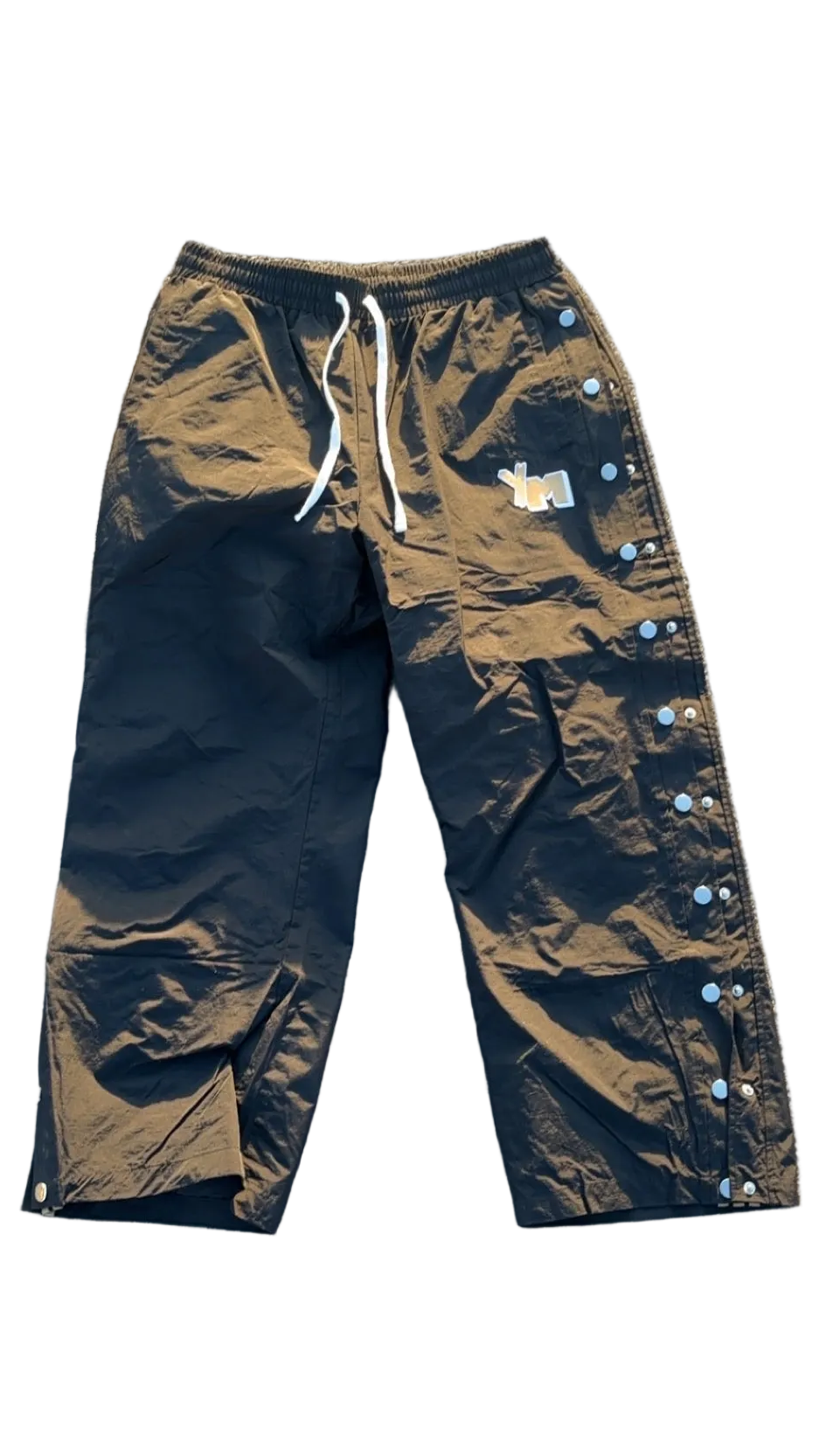 A pair of black track pants with an elastic waistband and drawstring, featuring 'YM' on the leg for "Yo! Martez."