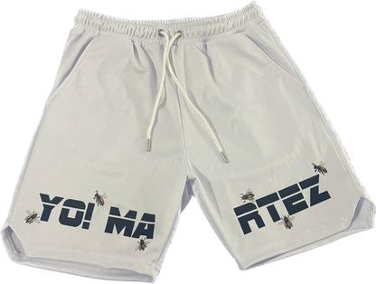 A pair of white athletic shorts with text and bee graphics on the legs, featuring an elastic waistband with drawstrings.